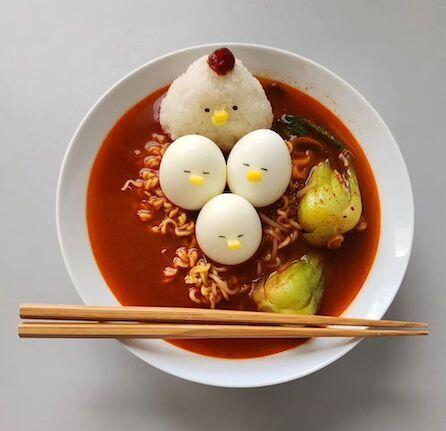 A bowl of ramen with the rice and eggs decorated so that they look like a chicken with her chicks.